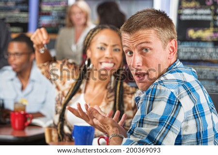 Angry young woman threatening rude man in cafe