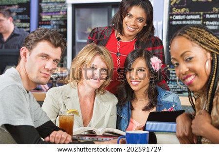 Diverse group of grinning students in cafe