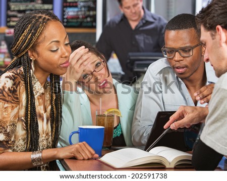 Worried young student with friends studying in cafe