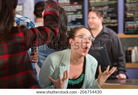 Emotional white female customer in line at coffee house