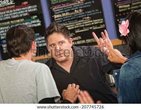 Cafe owner talking with rude customers in line