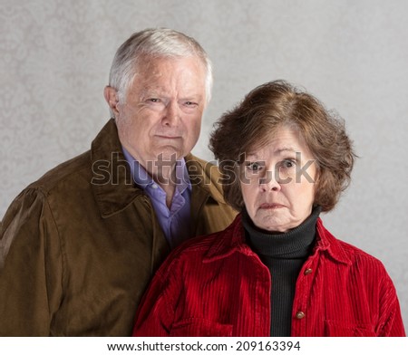 Pair of serious senior adults in jackets