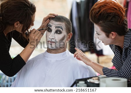 Group of clowns backstage with make up artist