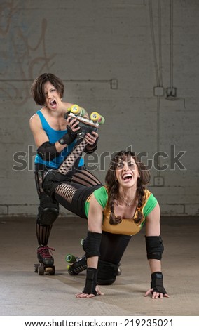 Bully roller derby skater twisting the leg of a woman