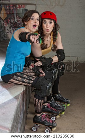 Pair of European female roller derby skaters as spectators