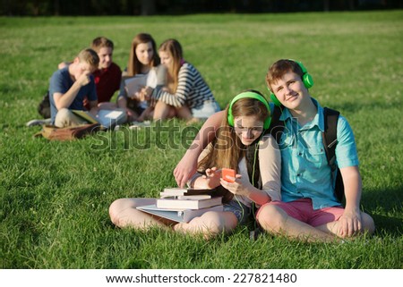 Cute student teen couple listening to music outdoors