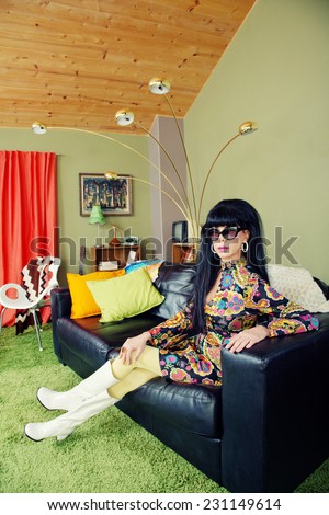 Calm groovy woman sitting on leather sofa