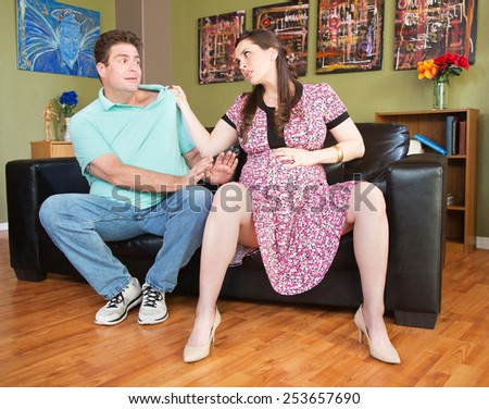 Angry expecting mother grabbing the collar of husband