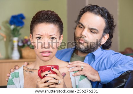 Concerned man with anxious Black woman holding mug