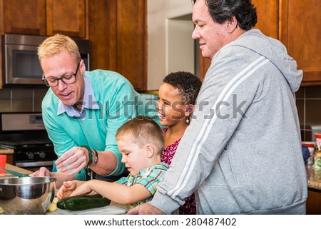 Happy gay dads with their children in the kitchen