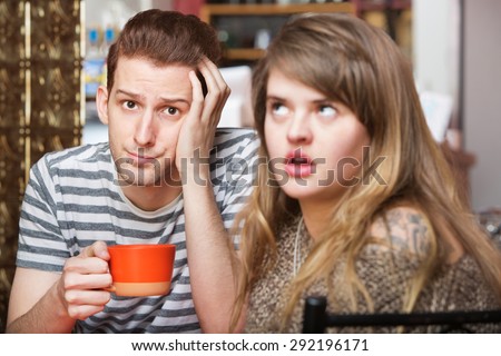 Young Caucasian couple having coffee and communication problems