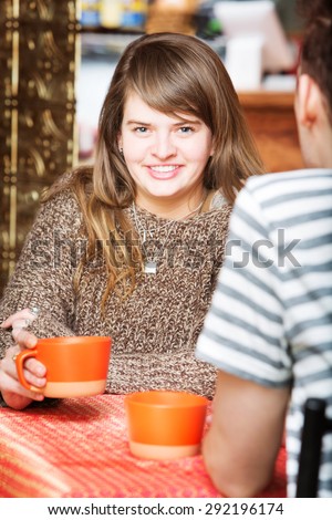 Happy Caucasian female having coffee with friend
