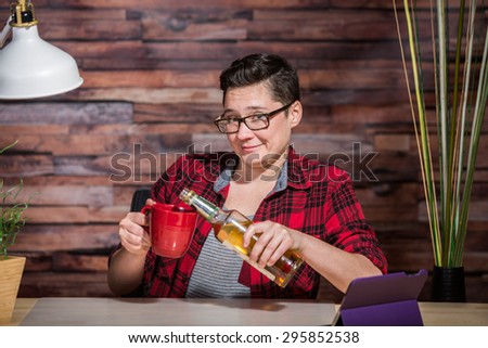 Grinning woman pouring whiskey into coffee mug