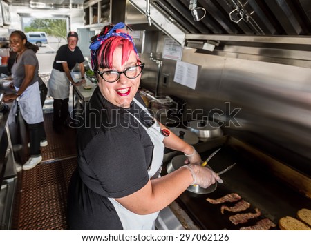 Happy pink haired chef grills bacon on a food truck