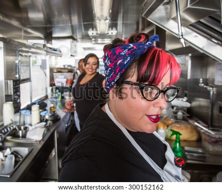Female chef with pink hair working on food truck