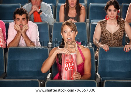 Surprised people with eyes wide open in theater