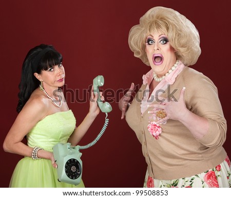 Retro-styled woman holding telephone with scared drag queen