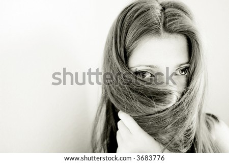 the quintessence of shyness, portrait of a young woman hiding her face with long straight brown hair