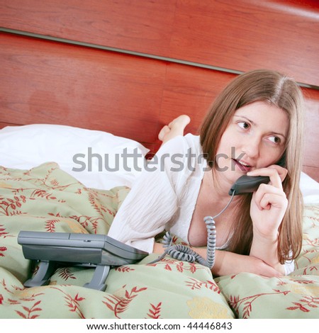 Young woman calling for room service in hotel interior
