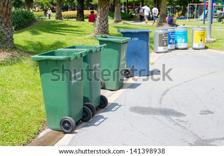 A group of Garbage cans on the side of the road