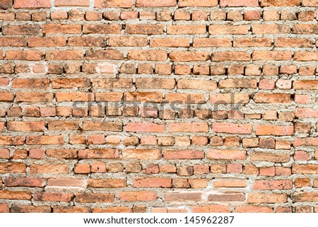 Red brick background: closeup of an old uneven brick wall.