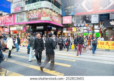 HONG KONG - FEBRUARY 07: People walking across Hennessy Road, Causeway Bay in front of a big department store Sogo at Day. Hong Kong February 07, 2015.