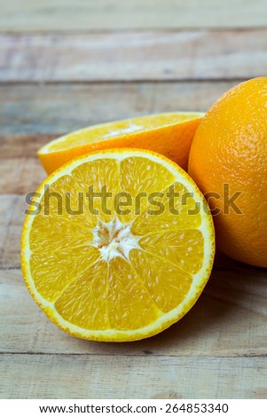 Organic orange fruit. Slices on wooden background
