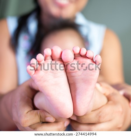 Mother holding baby feet, there is concept or idea of love
