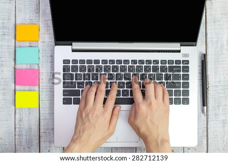 Top view of man hands working on laptop or tablet pc on wooden desk
