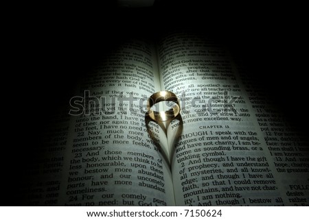 stock photo Wedding Ring and heart shaped shadow over a Bible