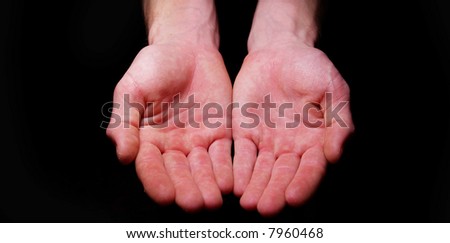 Hands begging alms on a black background