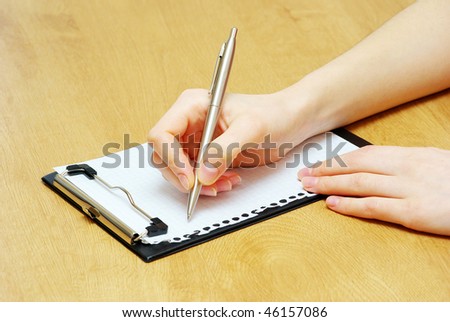 Pen in woman hand isolated on wood background