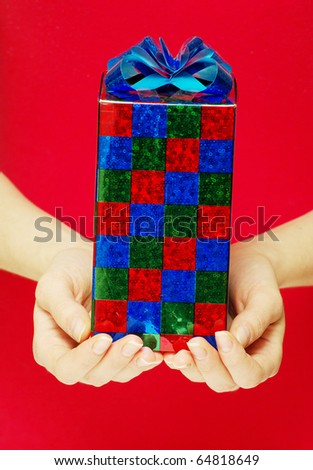 christmas gift in hands isolated on red