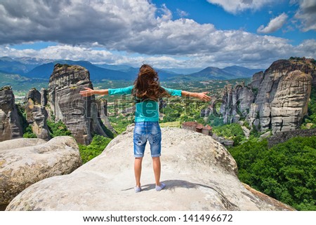 woman on top of a mountain and enjoying valley view