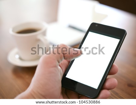 Man using smartphone, close-up, coffee and planning book on the background