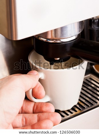 Man\'s hand with a cup of fresh coffee with foam