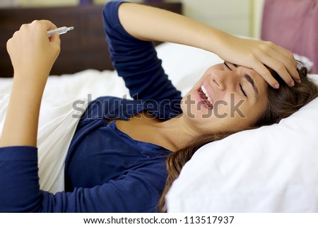 Depressed woman with flu in bed at home shouting