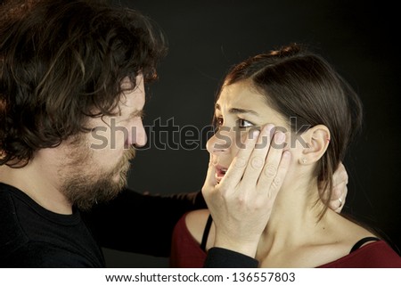 Husband scaring wife holding her face
