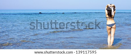 Gorgeous woman walking with hat in deep blue ocean/Fantastic beautifufl woman standing in the ocean