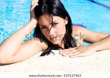 Gorgeous female model lying on color bench with wet hair looking