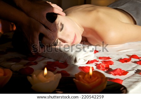attractive female getting recreation massage of head with closed eyes at spa salon