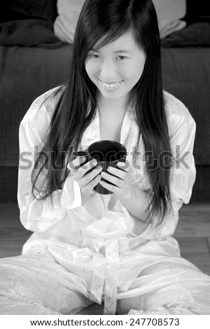 young chinese woman drinking a cup of tea. Black and white