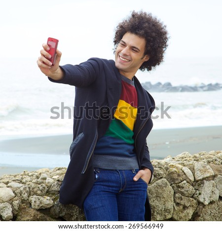 Handsome young hip man taking selfie with cell phone