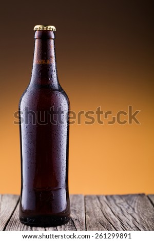 Beer bottle with water drops on a wooden table