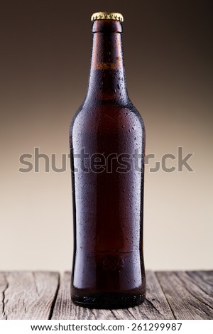 Beer bottle with water drops on a wooden table