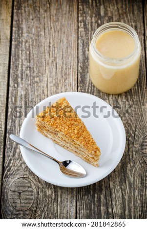 Delicious slice of honey cake on wooden background.