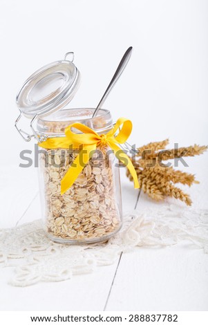 The oat flakes in glass jar on lace napkin.
