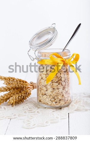 The oat flakes in glass jar on lace napkin.