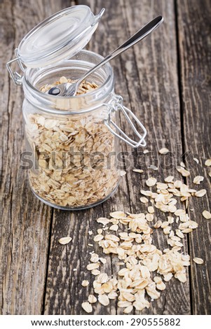 Oat flakes spilled out from glass jar.