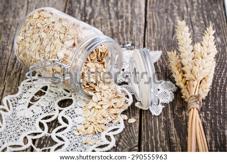 Oat flakes spilled out from glass jar.
